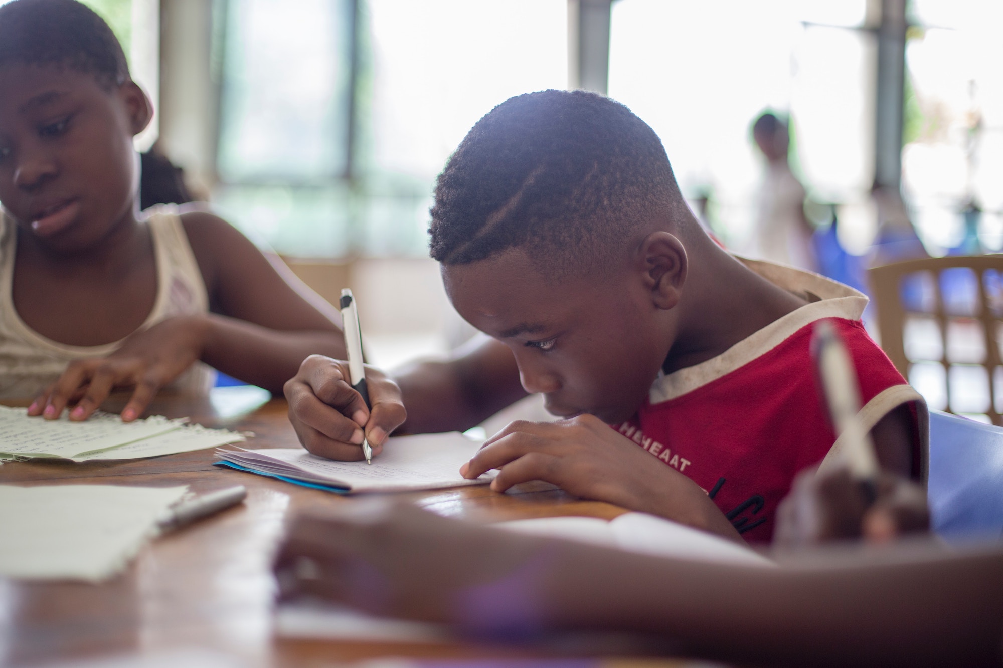 Young boy writing, developing skills to be an entrepreneur.