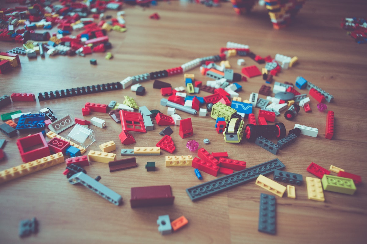 Lego pieces on the floor, requiring perseverance in a child to create something